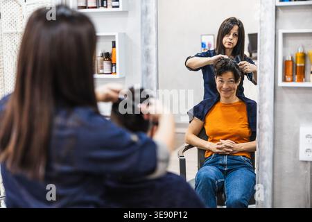 Hairdresser styling woman's short hair in a salon Stock Photo