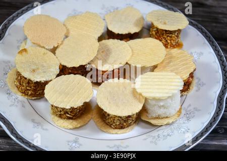 Assorted small, sweet treats, thin, crispy wafers sandwiching patties of sesame, peanuts or coconut, often held together by honey or sugar, popular on Stock Photo