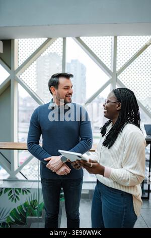 Colleagues collaborating and discussing business ideas with digital tablet Stock Photo