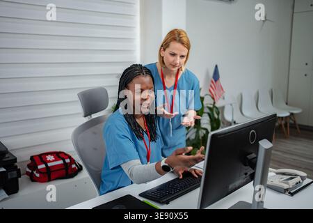 Healthcare team collaborating on computer in medical office Stock Photo