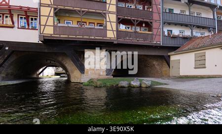 Erfurt, Germany – 10.04.2026: View from the bank of the river Gera to two of the arches of the famous Kraemerbruecke across the small river Stock Photo
