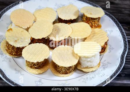 Assorted small, sweet treats, thin, crispy wafers sandwiching patties of sesame, peanuts or coconut, often held together by honey or sugar, popular on Stock Photo