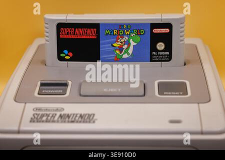OURENSE, SPAIN - APRIL 5, 2026: Super Nintendo Entertainment System (SNES) with game cartridges including Super Mario titles and controller, classic 1 Stock Photo