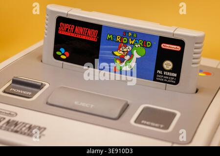OURENSE, SPAIN - APRIL 5, 2026: Super Nintendo Entertainment System (SNES) with game cartridges including Super Mario titles and controller, classic 1 Stock Photo