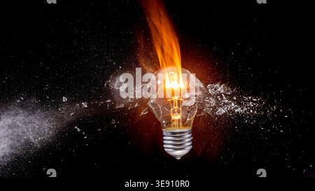 Light real bulb exploding with glass shards Stock Photo