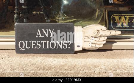 Any questions symbol. Concept words Any questions on beautiful wooden black sign as a hand. Beautiful store display background. Business and Any quest Stock Photo