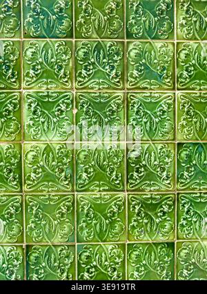 Pattern of green glazed ceramic tiles with embossed floral art nouveau motifs arranged in a repetitive grid lagos algarve portugal Stock Photo