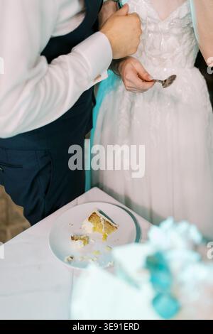 Marriage celebration moment. Bride and groom lovingly cut cake together amidst celebration Stock Photo