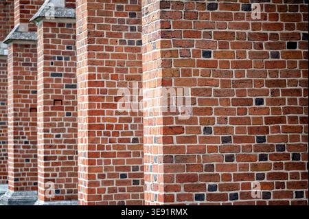 Bricks are stacked to create a series of columns on the exterior of an old building Stock Photo