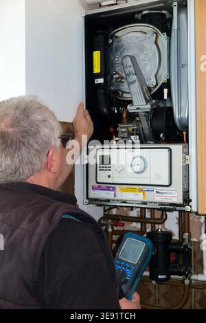 Gas engineer performing Central heating Combi boiler annual service and gas safety test for a landlord in a rental house property. Gas Safe technician / Which? Trusted Trader. UK (148) Stock Photo