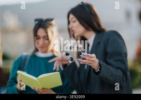 Two students examining a molecular model and reading notes on a university campus Stock Photo