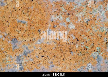Rusted metal surface close up with orange and brown oxidation creating a rough, weathered background pattern, illustrating decay and age through textu Stock Photo