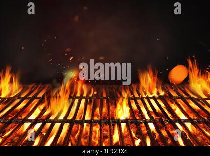 Fire embers particles over black background.  Grill Background - Empty Fired Barbecue On Black . Abstract dark glitter fire particles lights. Stock Photo