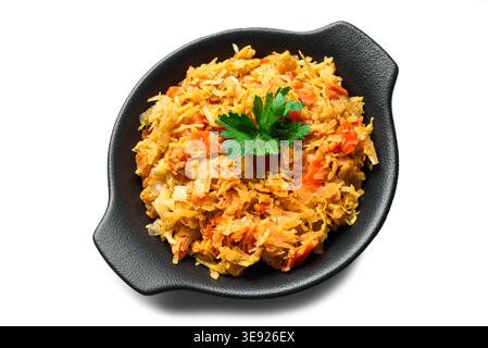 Stewed cabbage in black pan isolated on white background, angle view, design element. Braised sauerkraut side dish. Homemade finely cut white cabbage Stock Photo