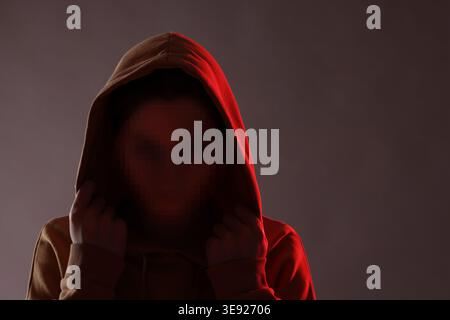Anonymous woman with pixelated face on dark background Stock Photo