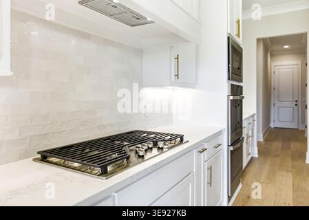Close-up of gas cooktop and white tile backsplash in a modern residential kitchen. Stock Photo