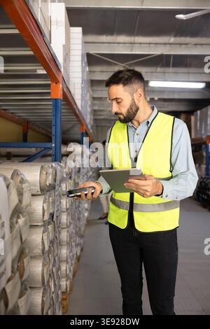 Worker scanning inventory barcode with scanner in industrial warehouse Stock Photo