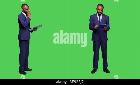 Startup manager thinking about new information on camera, brainstorming ideas and taking notes on clipboard files. Corporate employee wearing business suit and being thoughtful. Stock Photo