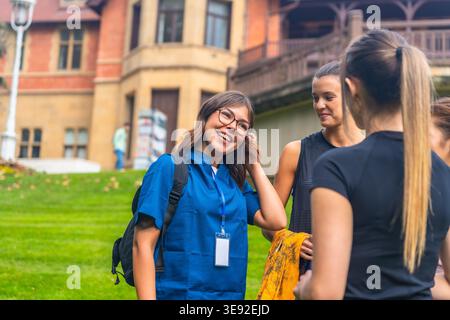 Group of young women smiling and talking on university campus Stock Photo