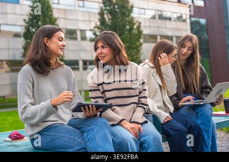 Young female student group discussing outdoors at university campus Stock Photo