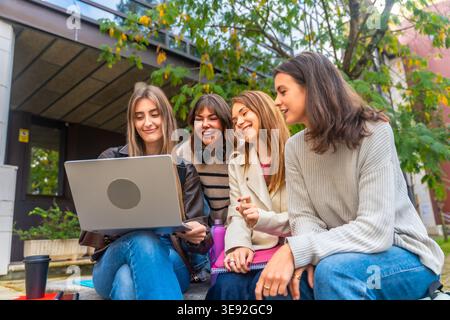 University students studying together laughing at campus Stock Photo