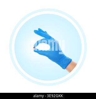 Medical icon showing a hand in a blue glove holding a capsule pill. Healthcare, pharmacy, and medication concept graphic isolated on a white backgroun Stock Photo