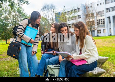 Young female university students studying outdoors on campus bench Stock Photo