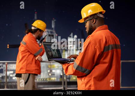 Offshore platform engineer uses laptop to review geological survey data on digital mapping interface. African american man evaluating seabed topography maps for site assessment planning Stock Photo