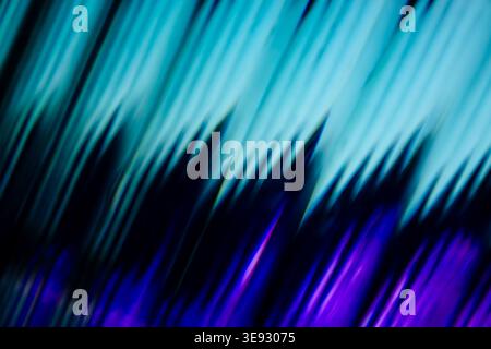 Abstract high contrast diagonal light rays in cyan and violet over black Stock Photo
