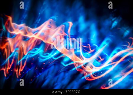 Energetic abstract light trails of orange and cyan blue resembling electric plasma waves Stock Photo