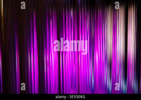 Vertical cascade of intense magenta and purple light streaks on a dark abstract background Stock Photo