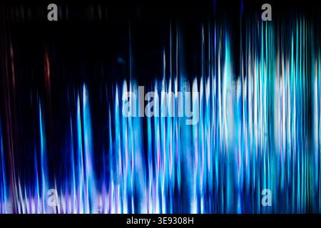 Vertical array of glowing blue and cyan light streaks against a black background Stock Photo