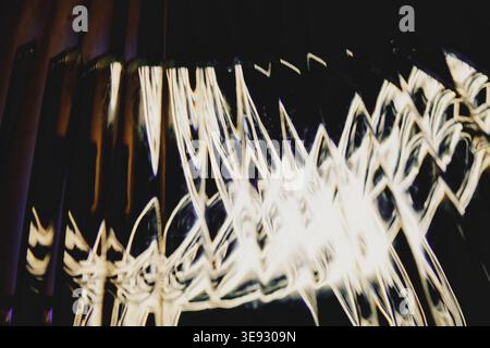 Golden abstract light trails forming sharp geometric zigzags over a dark background Stock Photo