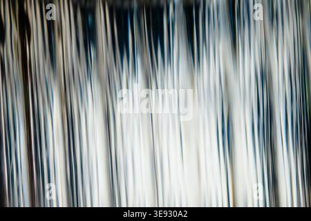 Abstract vertical blurred light streaks in blue and white tones resembling a waterfall Stock Photo