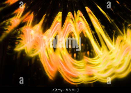 Warm orange and yellow kinetic light painting in a spiral motion Stock Photo