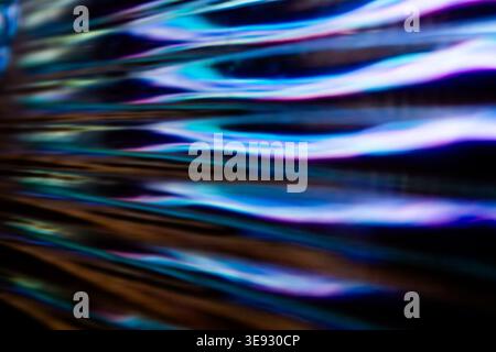Abstract background of wavy glass texture with vibrant blue and purple light reflections Stock Photo
