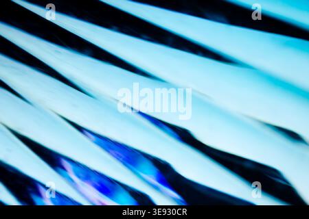 Macro shot of sharp geometric glass edges with bright blue glowing highlights Stock Photo