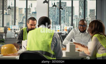 Architects and engineers collaborating on housing and city planning. office scene shows teamwork, innovation and design as real estate experts plan residential project development. Stock Photo