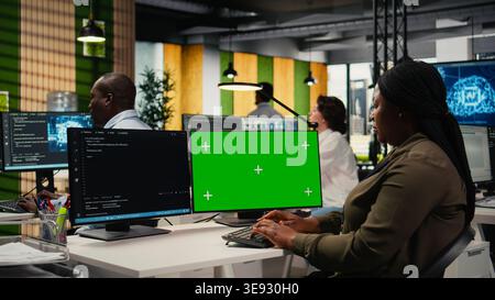 Green screen computer used by programmer in AI startup office to train predictive models for language processing tasks. IT expert uses deep learning technology on mockup PC, camera A Stock Photo