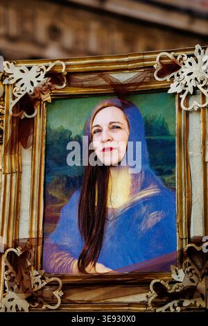 Venice, Italy - February 08, 2026: Woman in a blue dress mimics Mona Lisa, framed with decorative elements at Venice Carnival, highlighting cultural c Stock Photo
