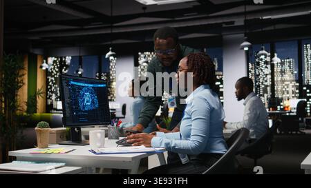 Black team of colleagues use artificial intelligence and predictive analytics, checking smart work solutions and cloud computing for adaptive strategies. AI engineering algorithms. Stock Photo