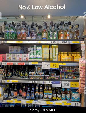 Tesco supermarket low and no alcohol drinks display in the UK, showing beers, ciders and spirit alternatives with prominent shelf pricing Stock Photo