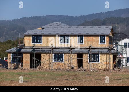 Half Moon Bay, California, USA - October 31, 2025: Scaffolding surrounds a two story home under construction near downtown. Stock Photo