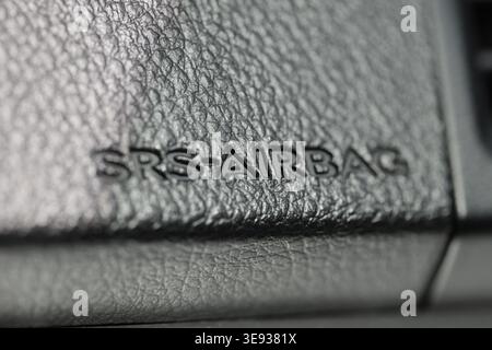 Macro detail of SRS Airbag embossed text on a black textured leather vehicle dashboard Stock Photo