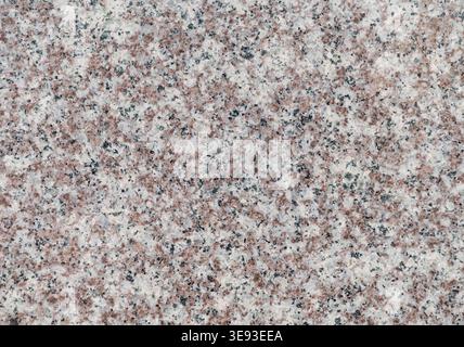 Polished granite stone surface with natural red and black speckles Stock Photo