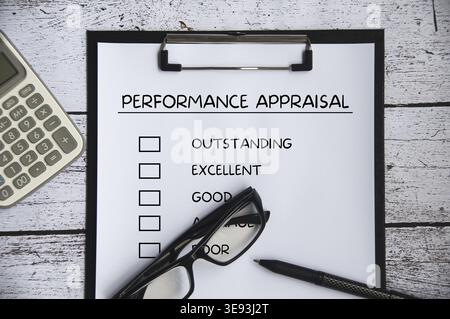 Top view of performance Appraisal checklist on clip board with pen, glasses and calculator background Stock Photo