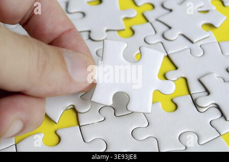 Close up of hand place missing jigsaw puzzle representing problem solving skill Stock Photo