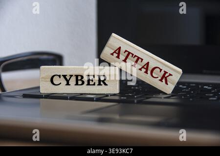 Cyber attack text on wooden blocks on top of a laptop. Internet security concept Stock Photo