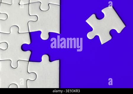 Connecting missing white jigsaw puzzle symbolizes partnership and unity on blue background Stock Photo