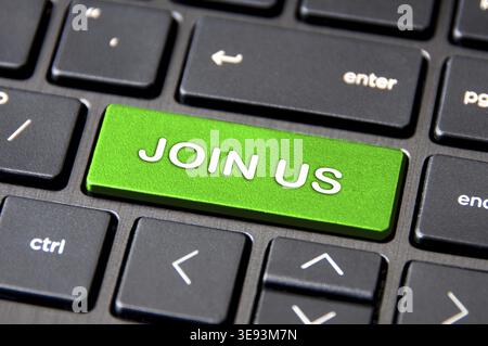 Online business concept - Laptop keyboard with green Join Us button Stock Photo